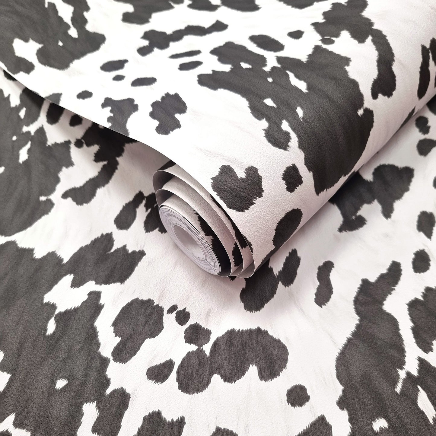 Holstein Black and White wallpaper roll showing the cowhide-pattern repeat