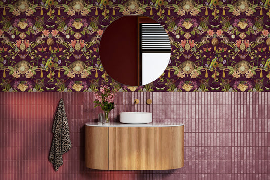 Bohème wallpaper in Berry on a feature wall, showing the mirrored curiosity-cabinet pattern