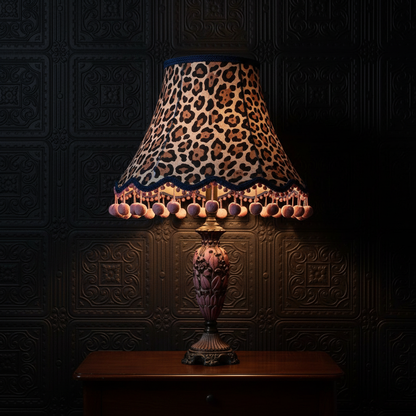 Large animal print lampshade with visible pink pom poms on tassels
